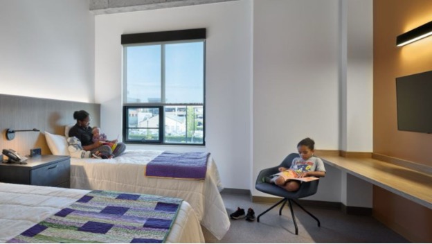 Private guest suite with two beds, natural light, and space for parents and children.